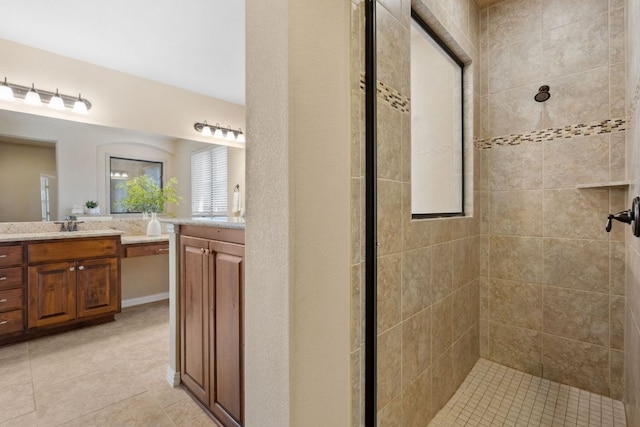 full bathroom featuring vanity, tile patterned floors, and tiled shower