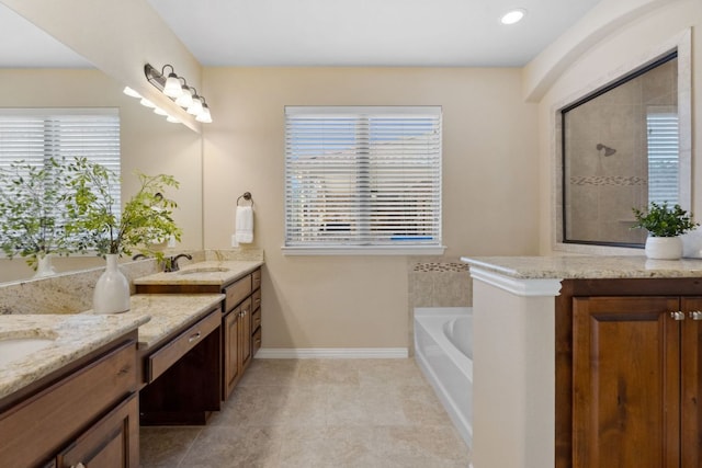 bathroom with a garden tub, a tile shower, tile patterned flooring, baseboards, and vanity