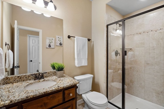 full bath featuring a shower stall, toilet, and vanity