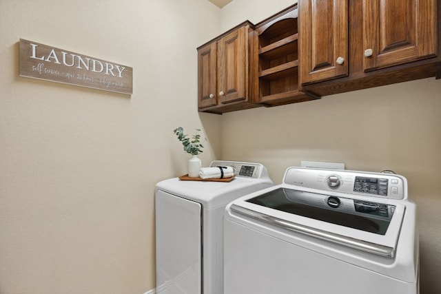 clothes washing area with washer and dryer and cabinet space