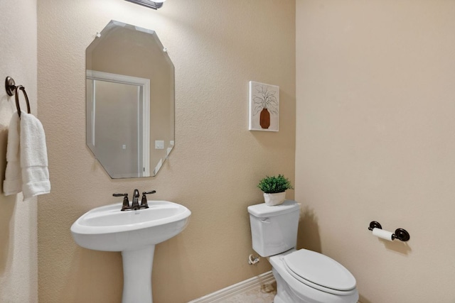 half bath with toilet and baseboards