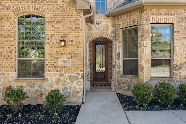 property entrance featuring stone siding and brick siding