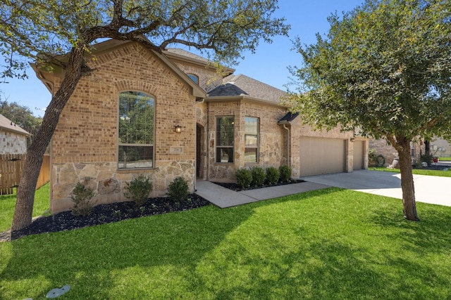 view of front of house featuring a front lawn, driveway, fence, a garage, and brick siding