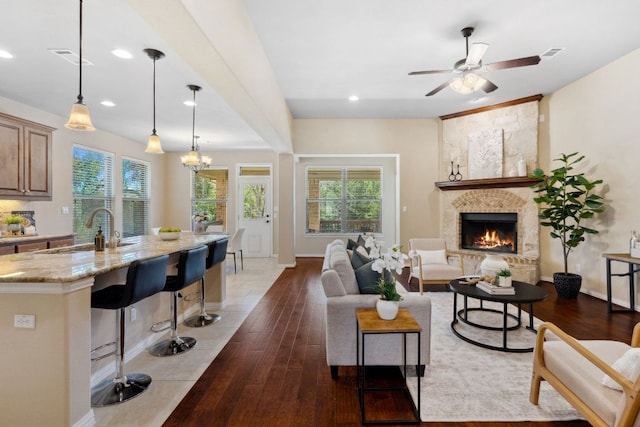 living area featuring visible vents, a fireplace, and wood finished floors