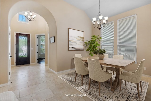 dining room featuring light tile patterned floors, arched walkways, high vaulted ceiling, and an inviting chandelier