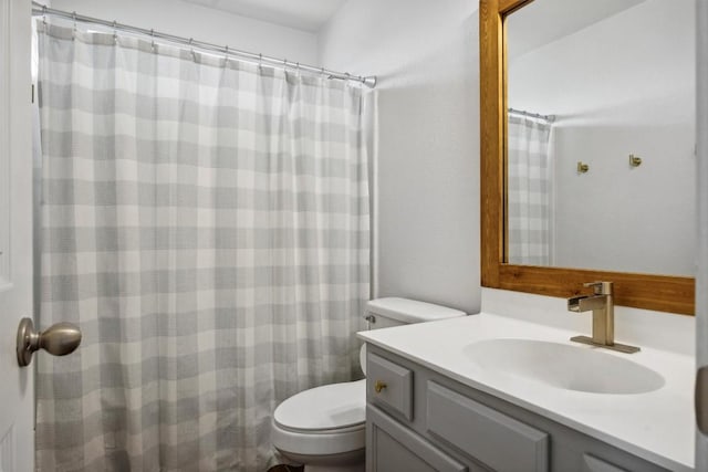 bathroom featuring a shower with shower curtain, toilet, and vanity