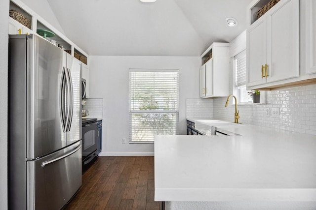 kitchen with black / electric stove, freestanding refrigerator, lofted ceiling, and a sink