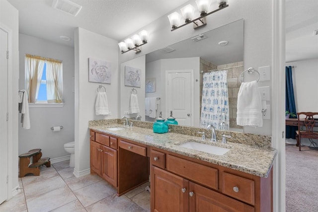 full bathroom featuring double vanity, toilet, visible vents, and a sink