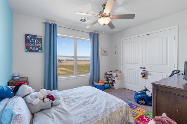 carpeted bedroom featuring a closet, visible vents, and ceiling fan