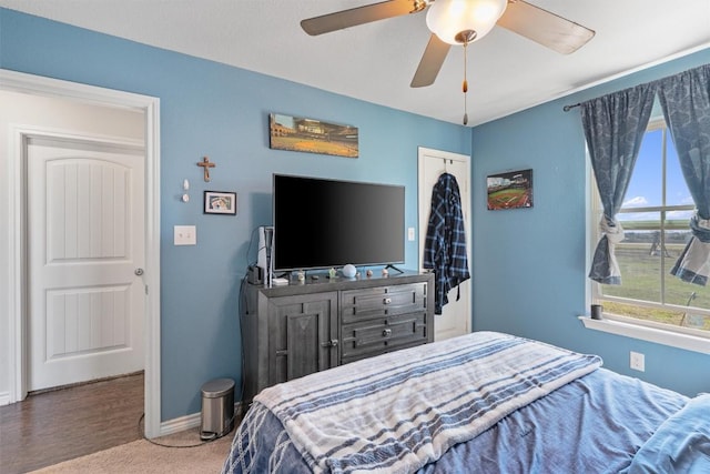 carpeted bedroom featuring baseboards and ceiling fan