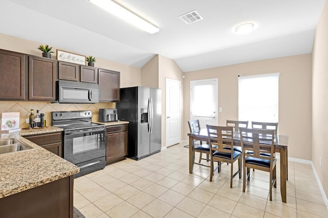 kitchen with vaulted ceiling, stainless steel fridge, dark brown cabinets, black electric range oven, and tasteful backsplash