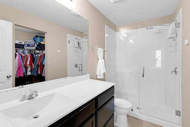 full bathroom featuring toilet, a stall shower, vanity, and tile patterned flooring