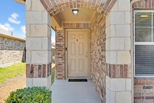 doorway to property featuring brick siding