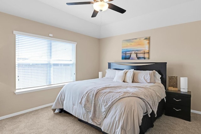 bedroom featuring light colored carpet, baseboards, and ceiling fan