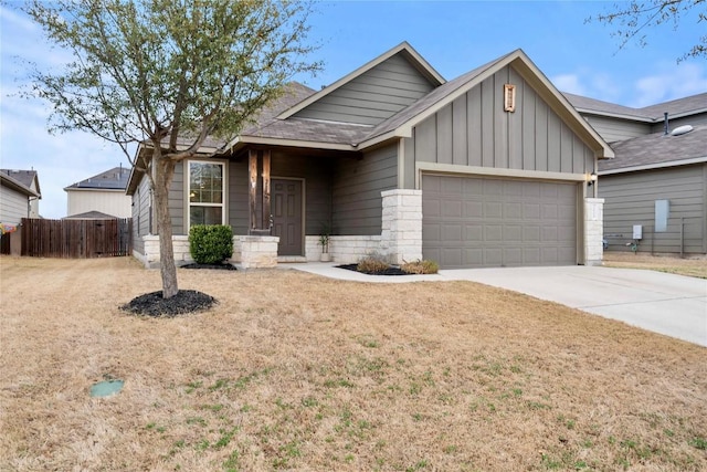 view of front of house featuring fence, an attached garage, a shingled roof, concrete driveway, and board and batten siding