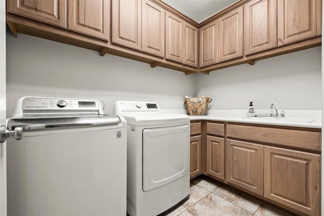 laundry area with cabinet space, washer and dryer, and a sink