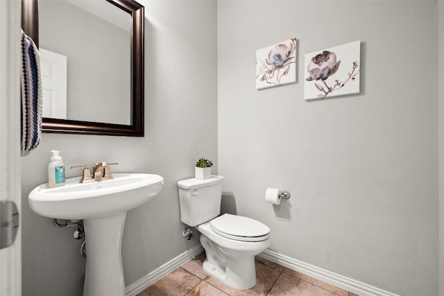 bathroom featuring tile patterned floors, baseboards, and toilet