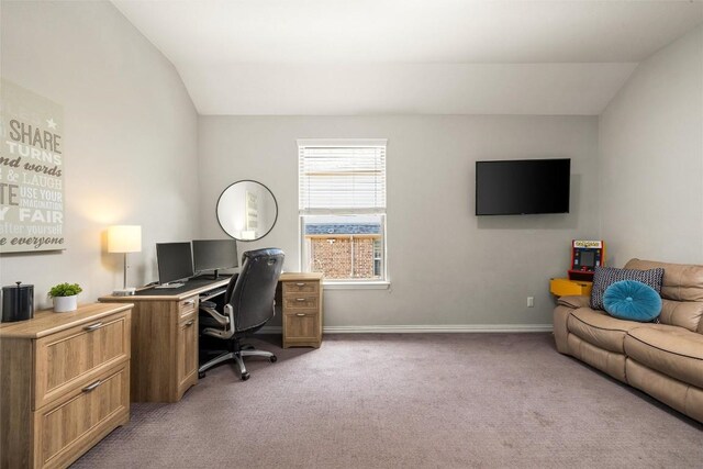 office space featuring light colored carpet, baseboards, and lofted ceiling