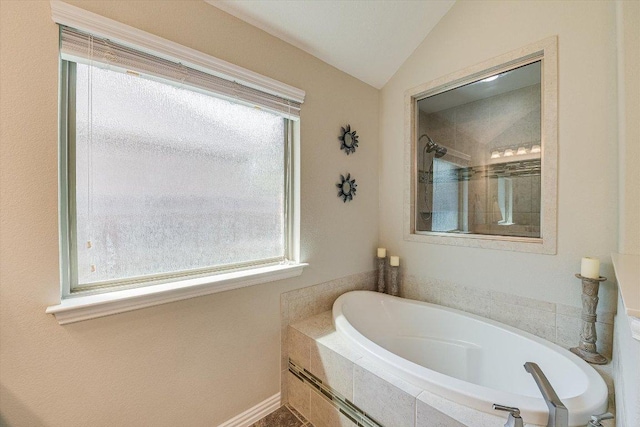 full bath with a garden tub, a wealth of natural light, lofted ceiling, and tiled shower