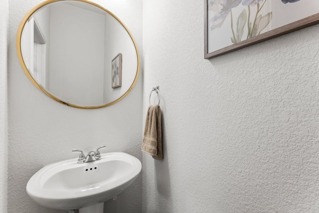 bathroom with a sink and a textured wall