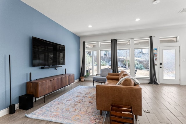 living room with recessed lighting, baseboards, and wood finished floors