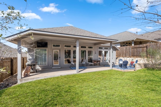 back of property featuring a patio, a yard, fence, and a shingled roof