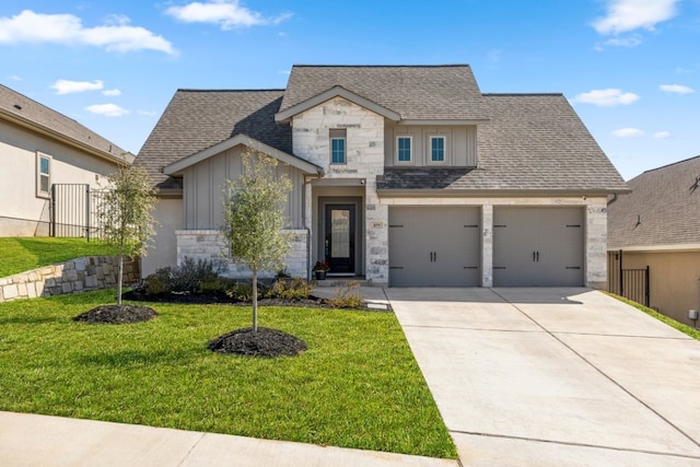 view of front of home featuring board and batten siding, a front yard, roof with shingles, stone siding, and driveway