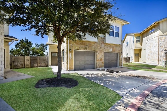 view of front facade featuring fence, driveway, an attached garage, a front lawn, and stone siding