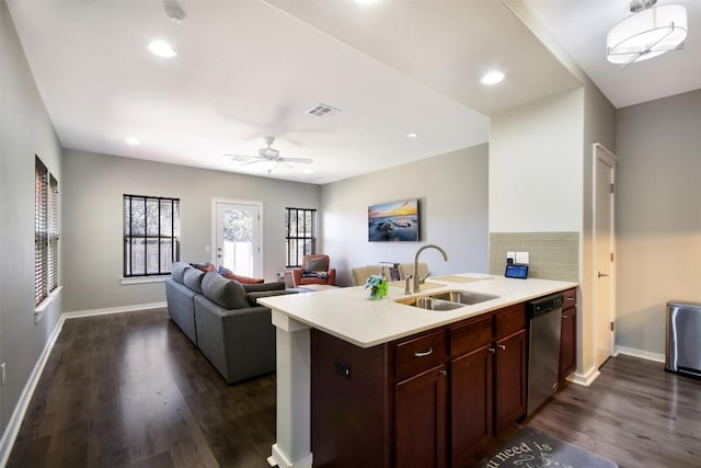 kitchen with backsplash, dark wood finished floors, dishwasher, light countertops, and a sink