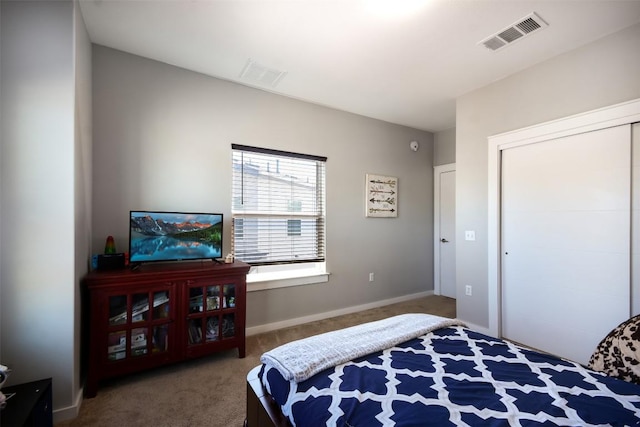 carpeted bedroom with a closet, visible vents, and baseboards