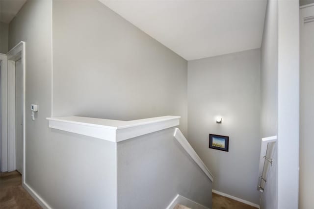 staircase featuring baseboards and carpet floors