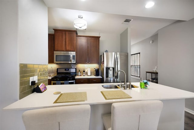 kitchen with appliances with stainless steel finishes, light countertops, and a sink