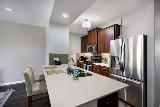 kitchen featuring a sink, light countertops, backsplash, and stainless steel appliances