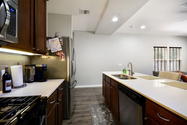 kitchen with visible vents, a sink, dark wood-style floors, stainless steel appliances, and light countertops