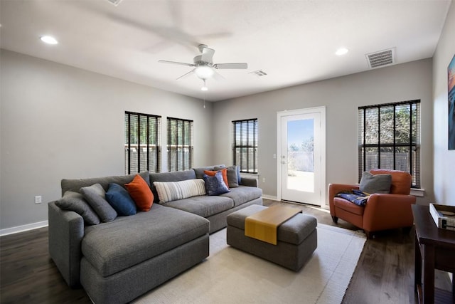 living room with visible vents, baseboards, wood finished floors, and a ceiling fan