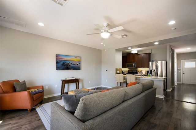 living room with visible vents, recessed lighting, baseboards, and dark wood-style flooring