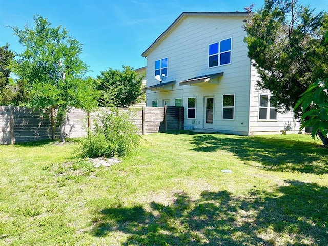 back of property with a yard and fence