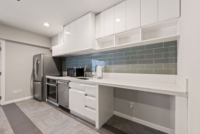 kitchen with white cabinetry, backsplash, and stainless steel appliances