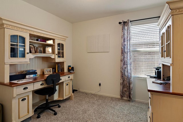 office area featuring a wealth of natural light, baseboards, light colored carpet, and built in study area