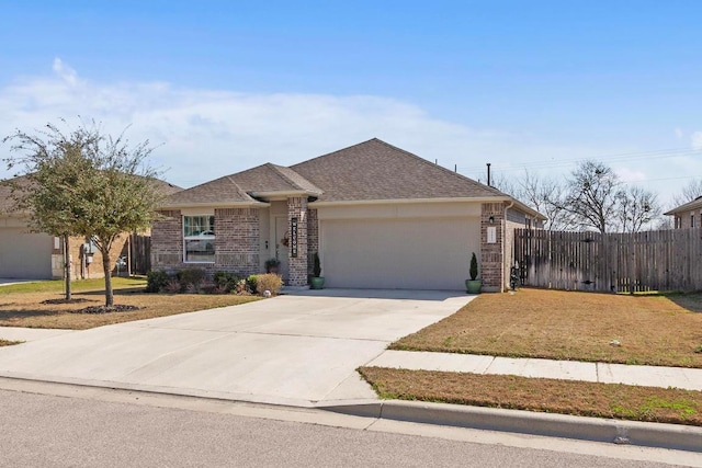 ranch-style house featuring driveway, fence, an attached garage, a shingled roof, and brick siding