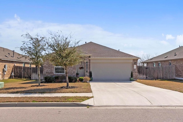 ranch-style home featuring fence, concrete driveway, an attached garage, a shingled roof, and brick siding