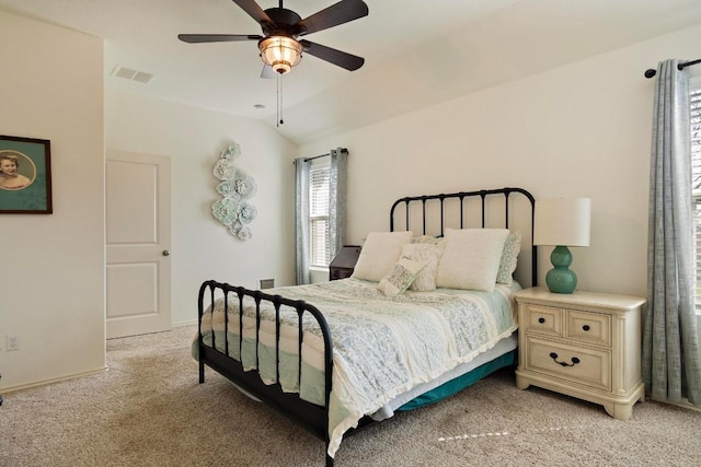 bedroom with visible vents, light colored carpet, a ceiling fan, and vaulted ceiling