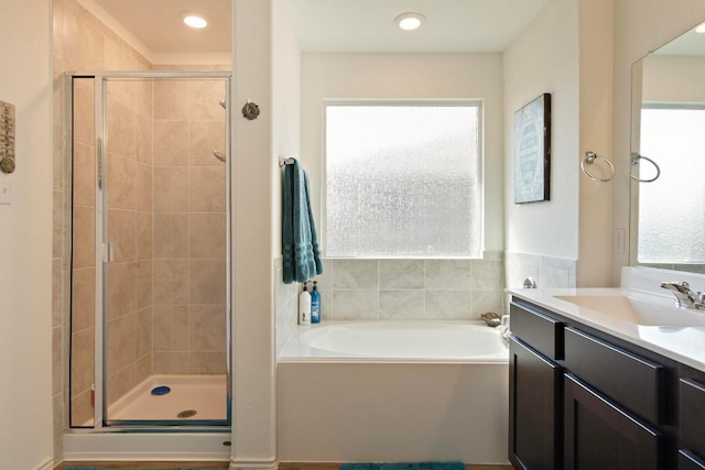 bathroom featuring a bath, recessed lighting, a stall shower, and vanity