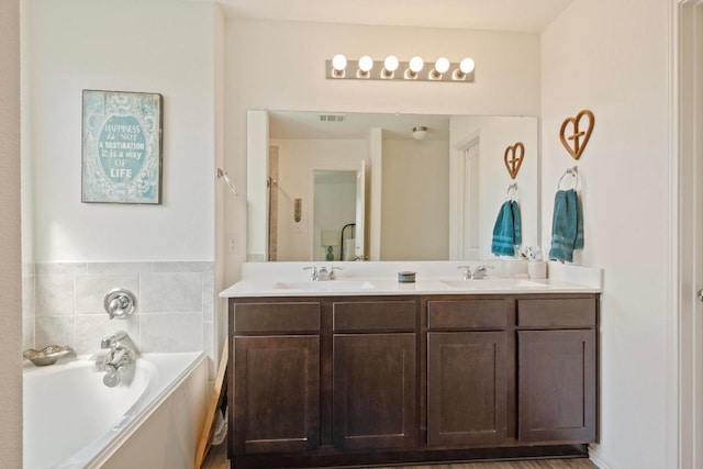 bathroom featuring a sink, visible vents, a garden tub, and double vanity