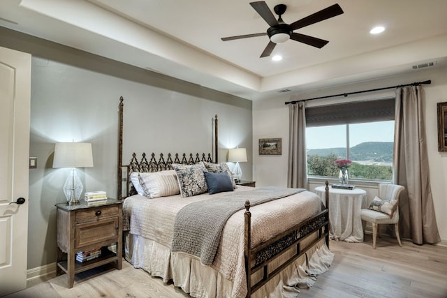 8205 Moon Rise Trl, Jonestown, TX 78645 - bedroom featuring light wood finished floors, recessed lighting, baseboards, a ceiling fan, and a raised ceiling