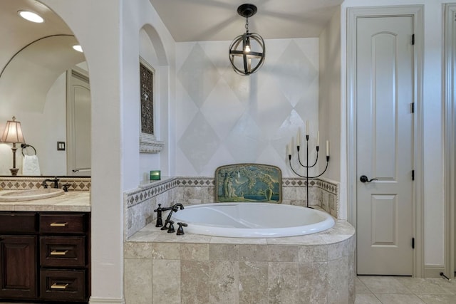 full bath featuring tile patterned floors, a garden tub, and vanity