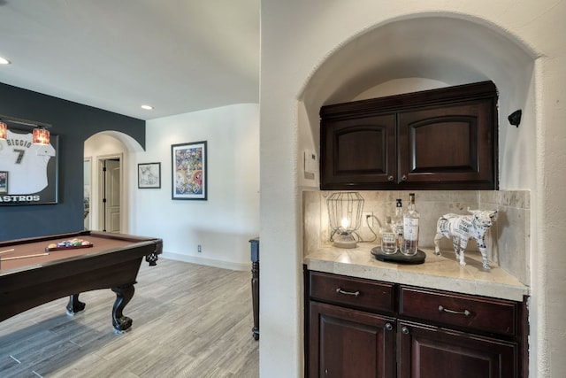 interior space featuring baseboards, recessed lighting, arched walkways, pool table, and light wood-style floors