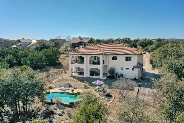 8205 Moon Rise Trl, Jonestown, TX 78645 - back of house featuring a balcony, a patio area, a tile roof, and stucco siding