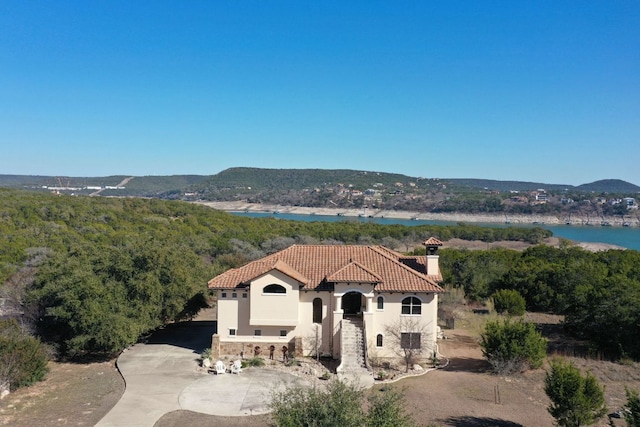 birds eye view of property with a view of trees and a water and mountain view