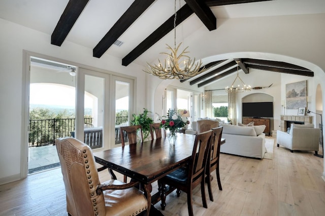 8205 Moon Rise Trl, Jonestown, TX 78645 - dining space featuring arched walkways, a chandelier, a ceiling fan, and light wood-type flooring